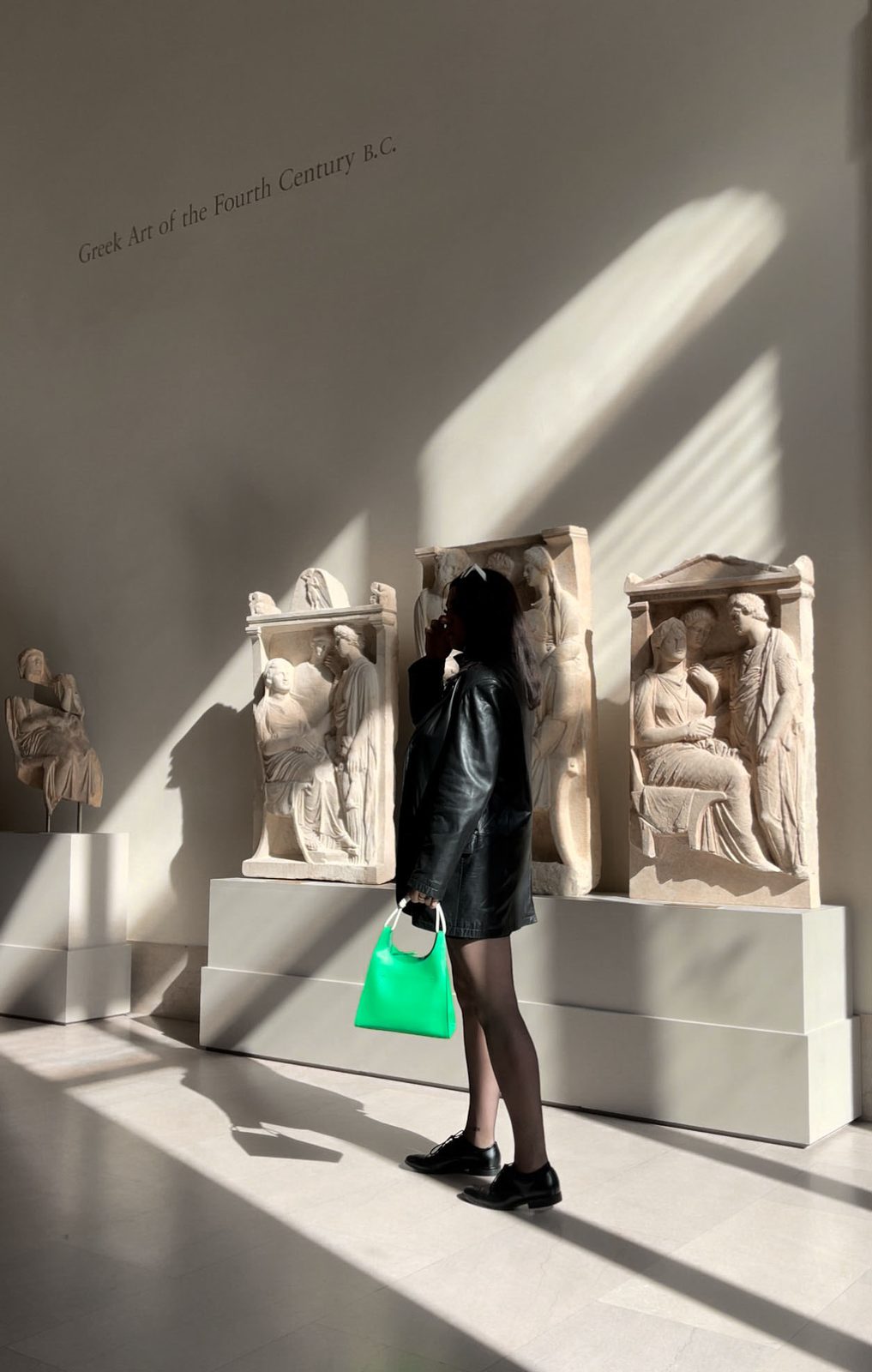 The image shows student Helena at a museum in front of statues.