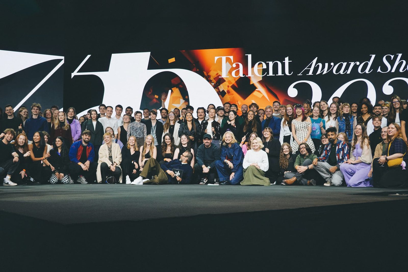 Gruppenaufnahme von etwa mehr als 50 Gewinnern des ADC Awards 2025 auf einer großen Bühne, wobei die Jurymitglieder vorne stehen.