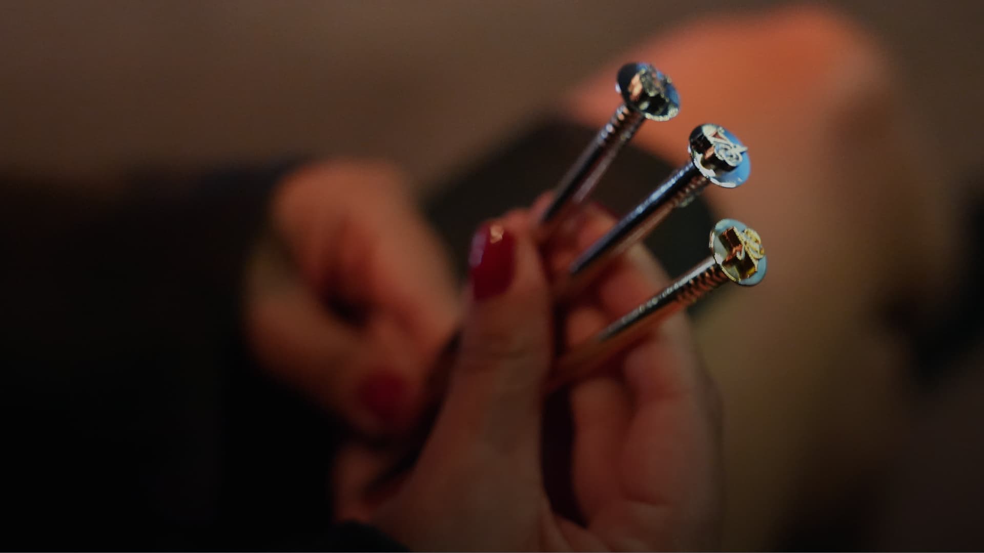 Eine Nahaufnahme von Larisas Hand, die die goldene, silberne und bronzene Nagel-Trophäe des Art Directors Club für Deutschland (ADC) hält.