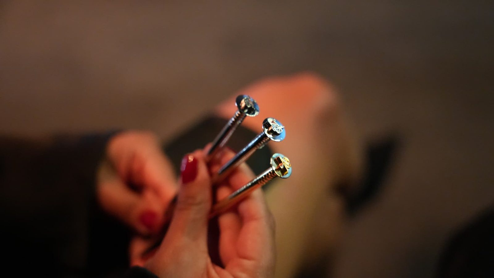 Eine Nahaufnahme von Larisas Hand, die die goldene, silberne und bronzene Nagel-Trophäe des Art Directors Club für Deutschland (ADC) hält.