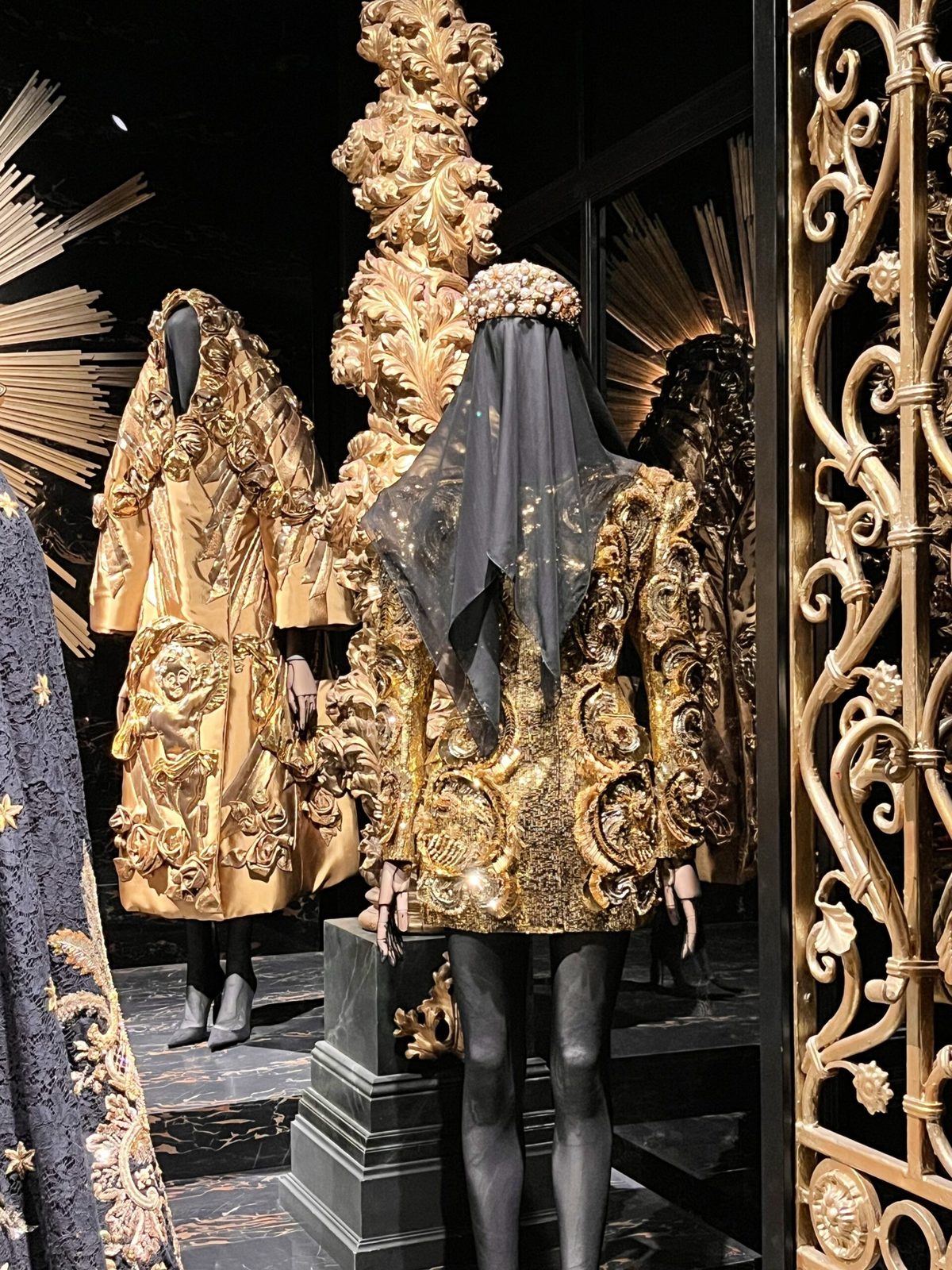 Ansicht von opulenten Kleidern mit goldenen Verzierungen und schwarzen Stoffen. Sehr edel und fast königlich.