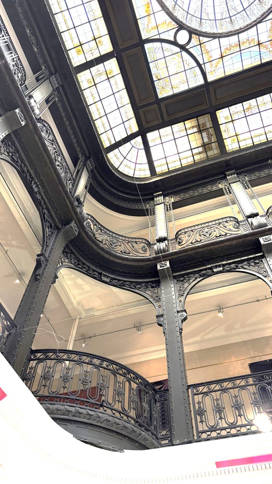 Blick auf ein kunstvolles Stahl- und Glasdach in Art Deko Stil mit kleinen Verzierungen, mit dekorativen Elementen und eleganten schwarz weißen Ästhetik, in einem historischen Gebäude in Paris