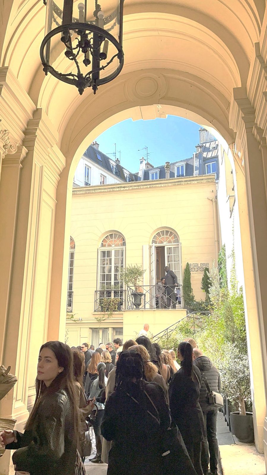 Eleganter Innenhof, in dem Besucher der Fashion Week Sekt und Wein genießen und sich unterhalten.