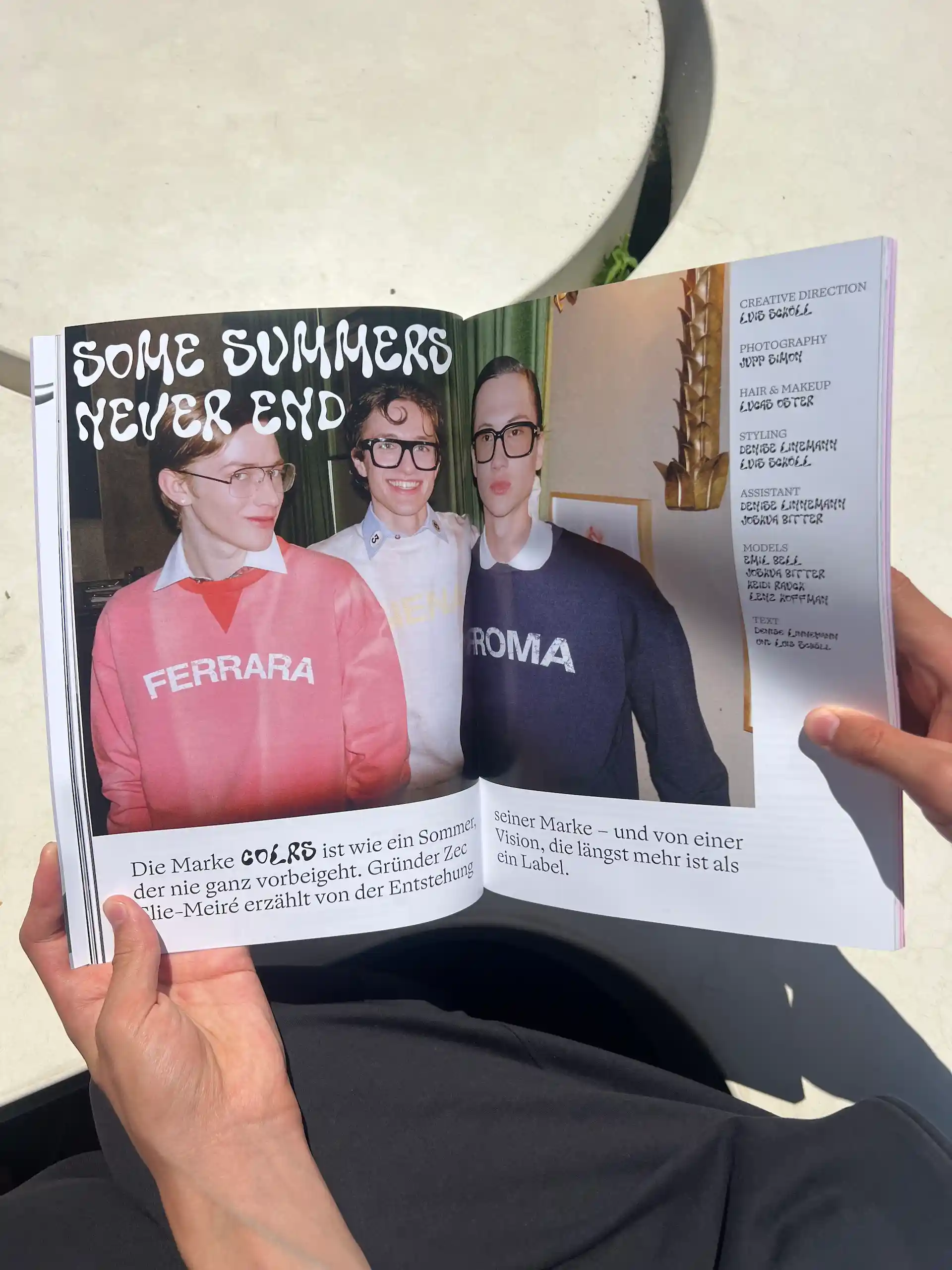 Hand hält eine aufgeschlagene Hotline-Seite mit Porträtfotografien