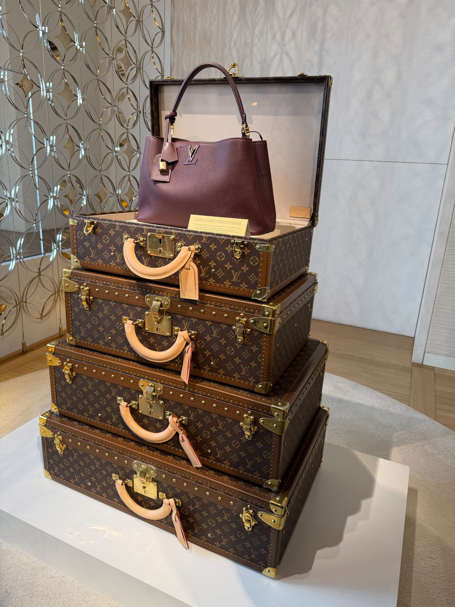 Elegante Louis‑Vuitton‑Tasche auf gestapelten Koffern – klassische Handwerkskunst und zeitloser Luxus stilvoll präsentiert.