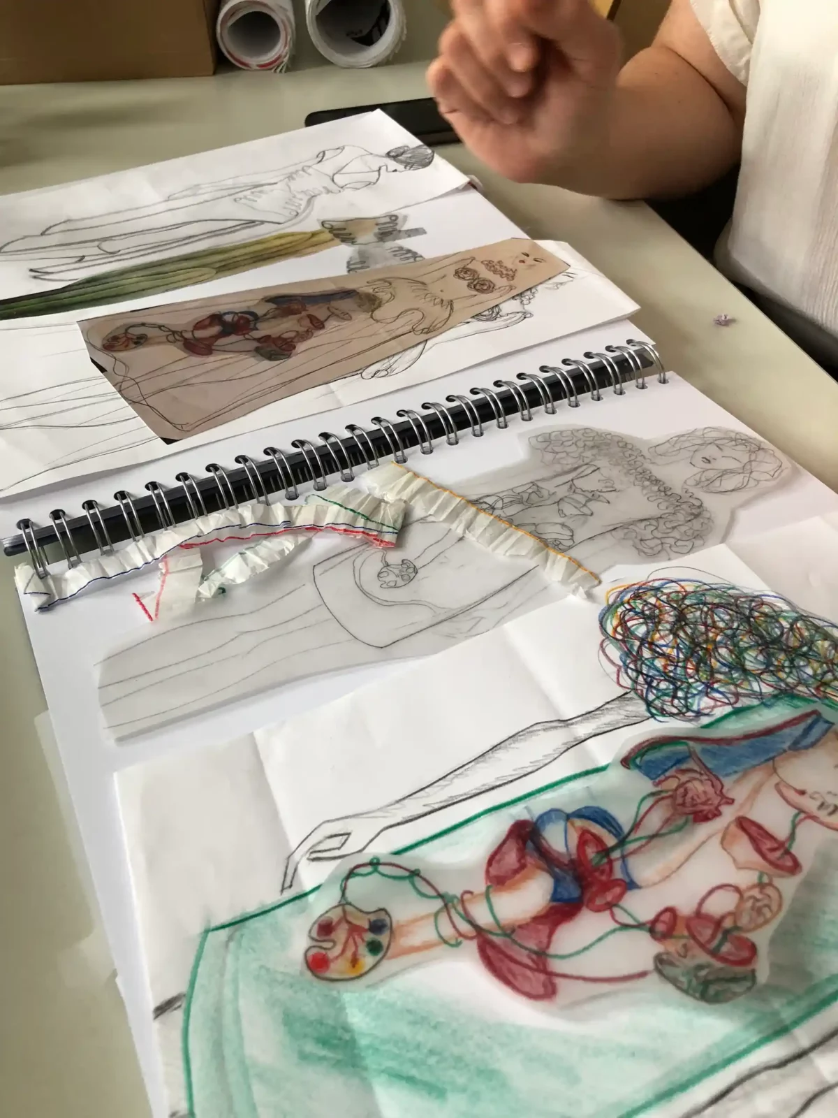 Zeichnungen in einem Skizzenbuch, das verschiedene Kostümbilder zeigt.