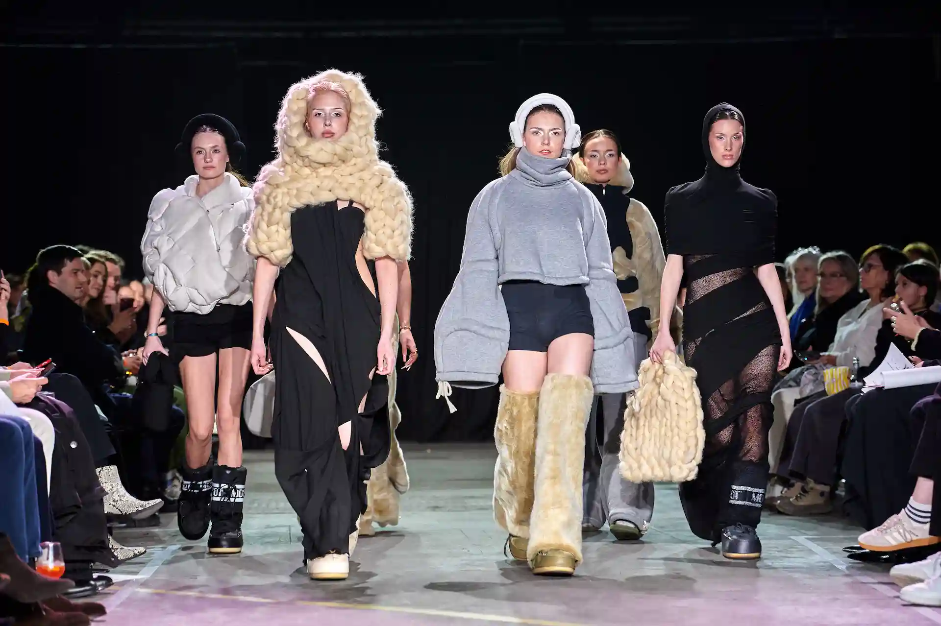 Mehrere Models präsentieren auffällige Kleider mit schrägen Woll-Elementen, auch als Taschen und Kopfbedeckungen.