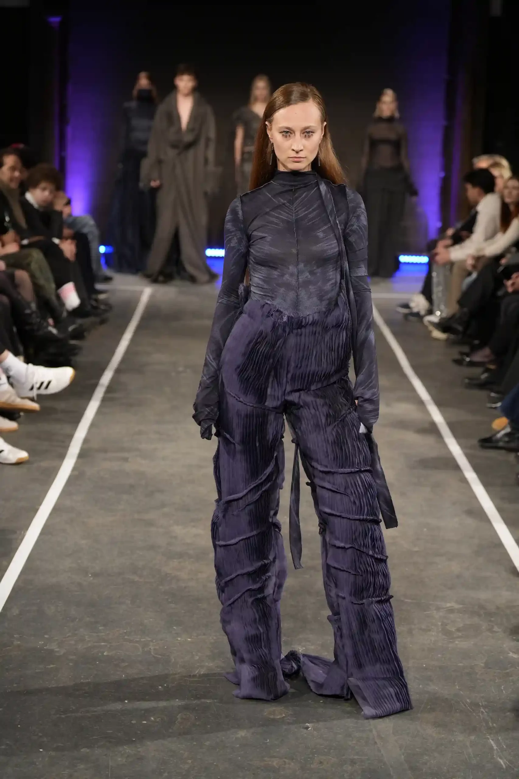 Model auf dem Laufsteg in einem eleganten lila Outfit