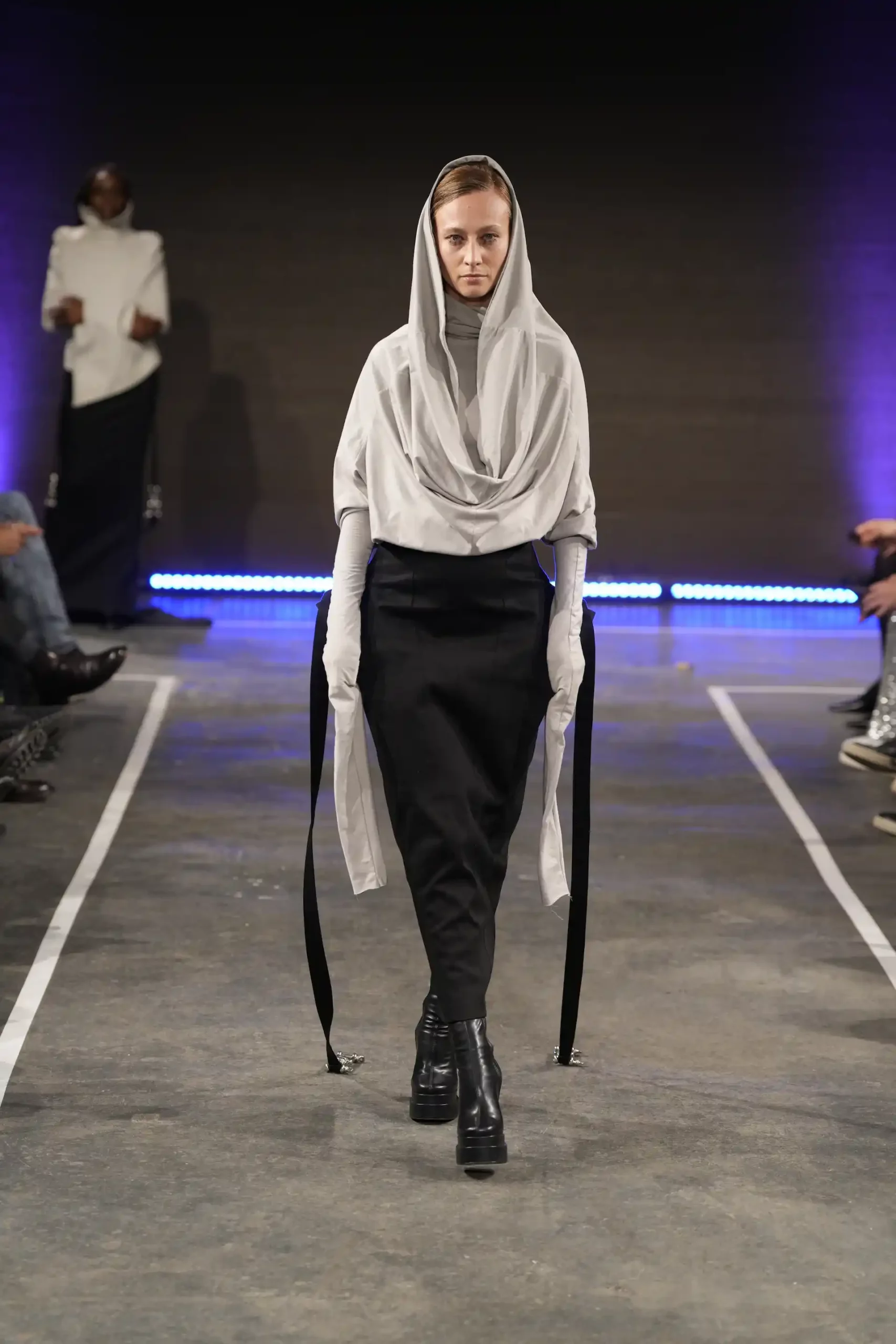 Minimalistischer Modeauftritt mit einem Model in schlichten, eleganten schwarz-weiß Outfits.