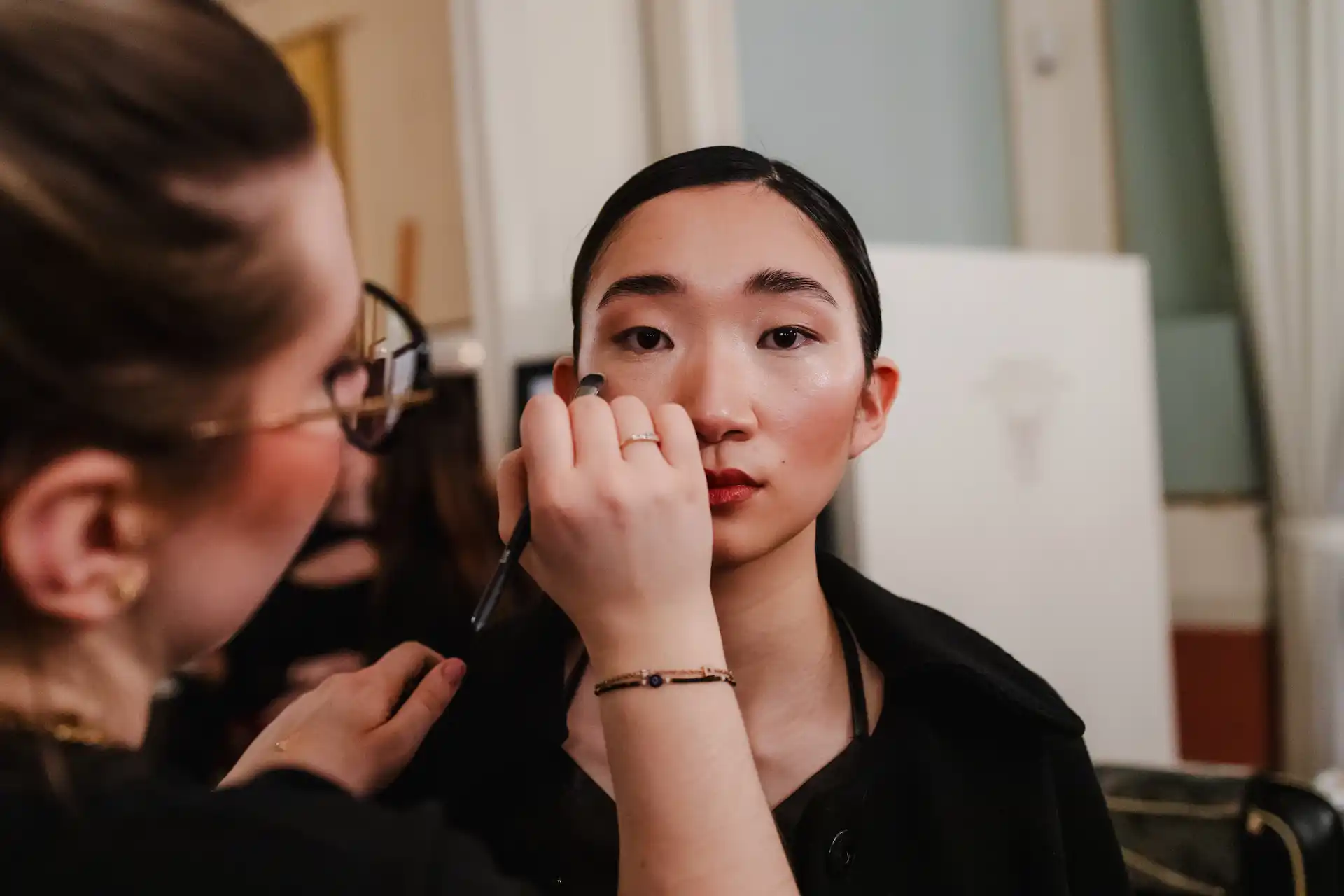 Professionelle Make-up-Artistin, die an einem Model arbeitet.