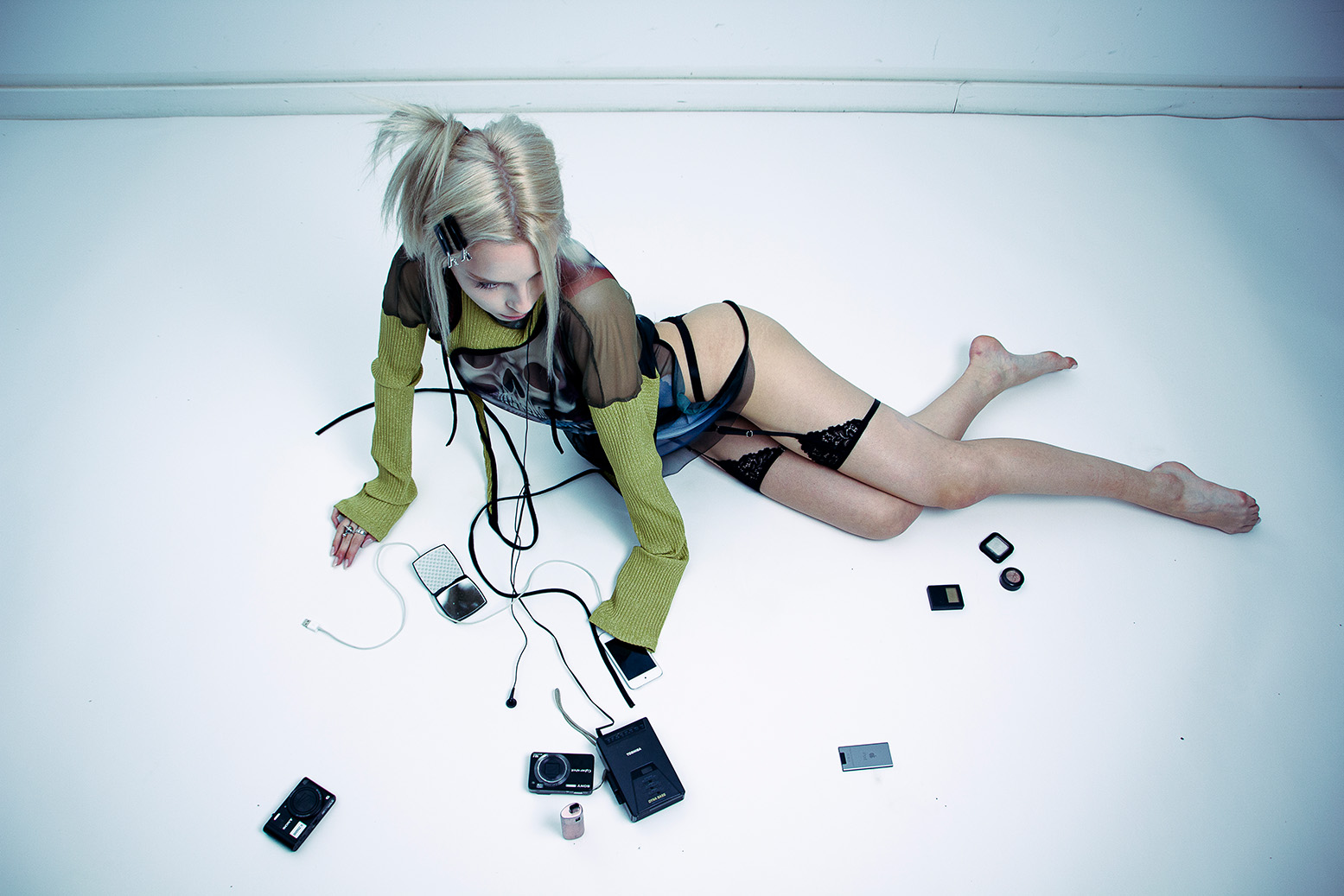 Model in schwarzem Riemchen-Look mit Kabeln und Smartphone – Editorial des Projekts Spac