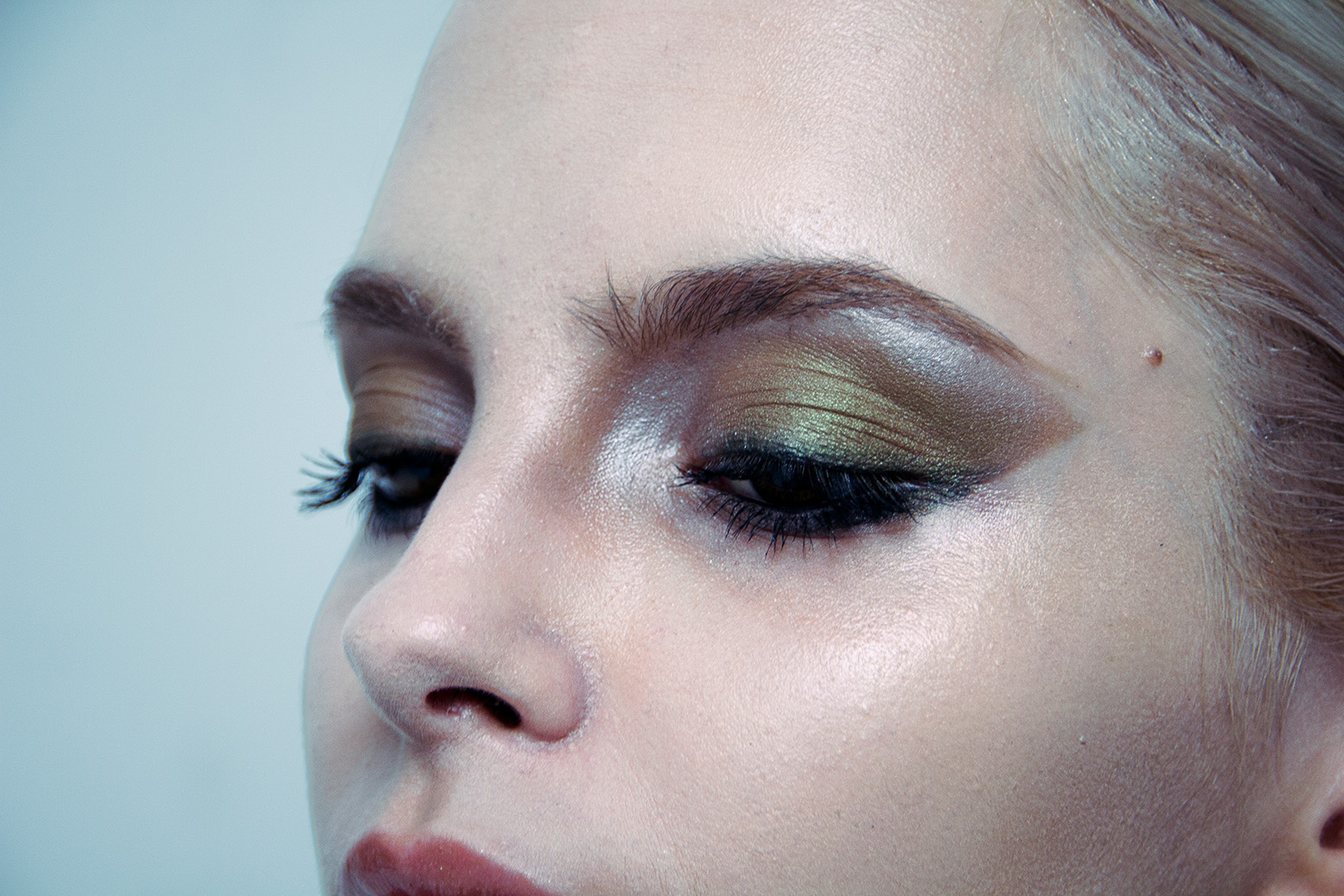 Extreme Nahaufnahme: grün schimmerndes Augen-Make-up eines Models