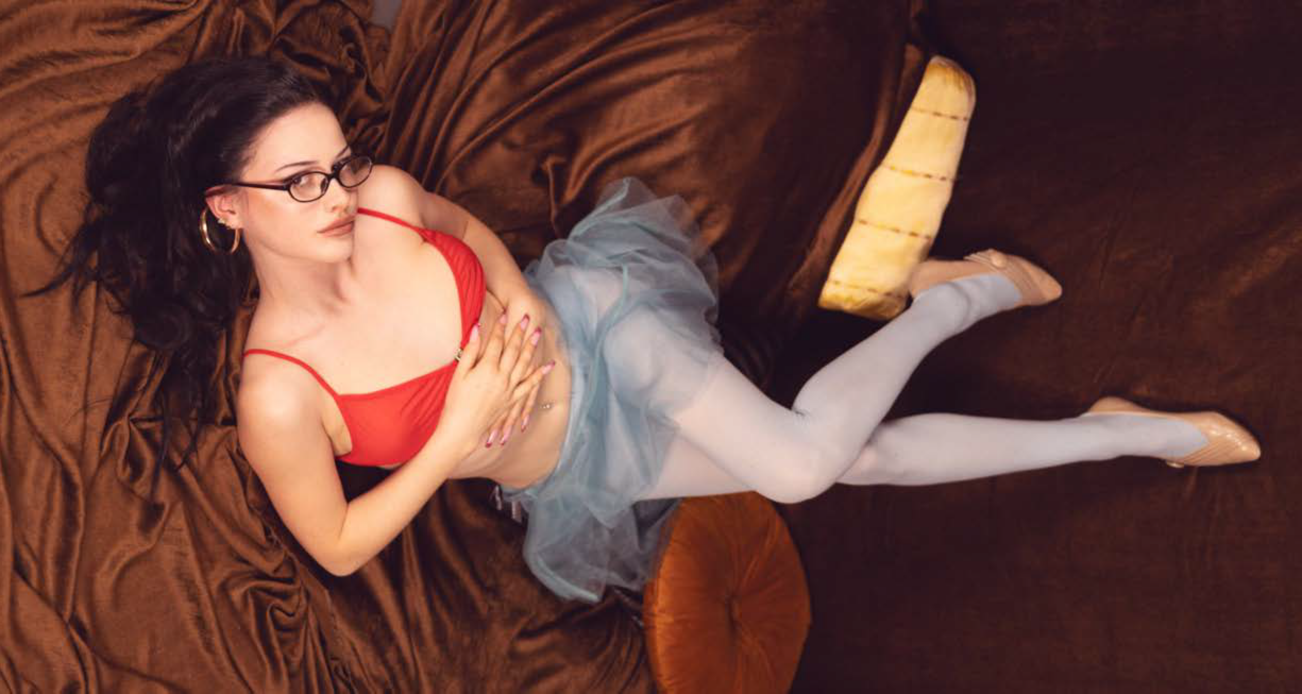 Model in rotem Top liegt in malerisch inszenierter Retro-Szene
